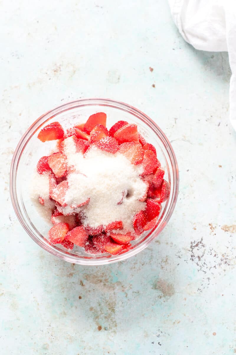 Sugar and sliced strawberries in a bowl