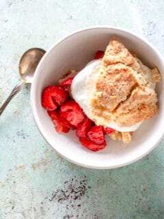 Close up of serving a strawberry shortcake with whipped cream