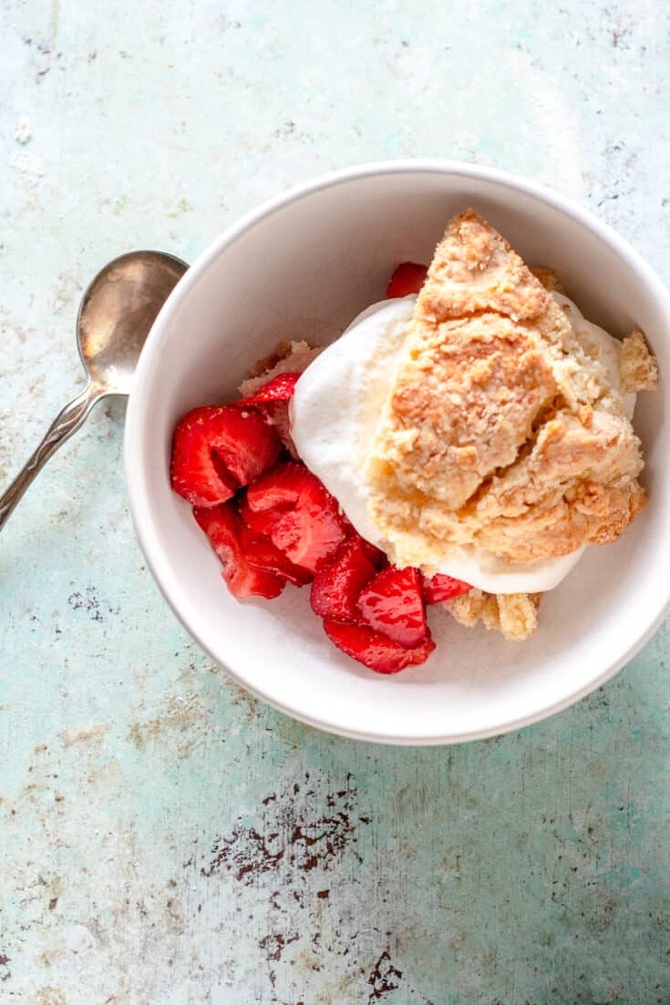 Close up of serving a strawberry shortcake with whipped cream