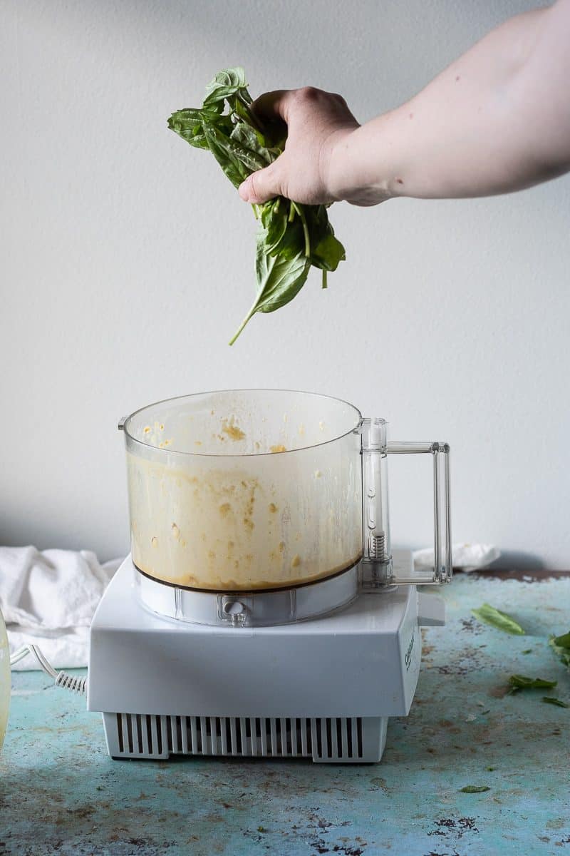 Basil being added to a food processor