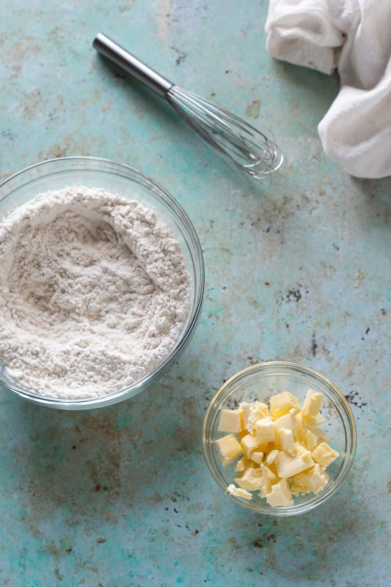 Cubes of unsalted butter a bowl next to the flour mixture