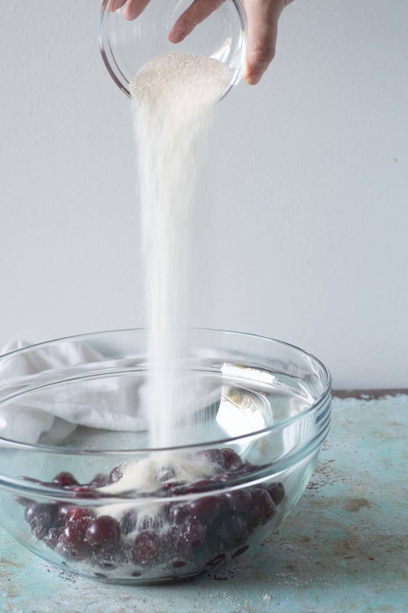 Pouring sugar over cherries