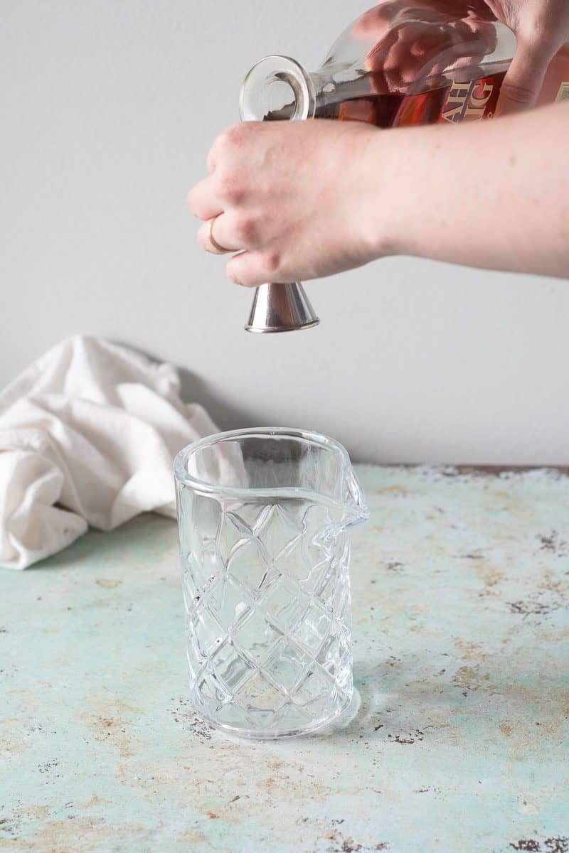 Measuring bourbon into a jigger