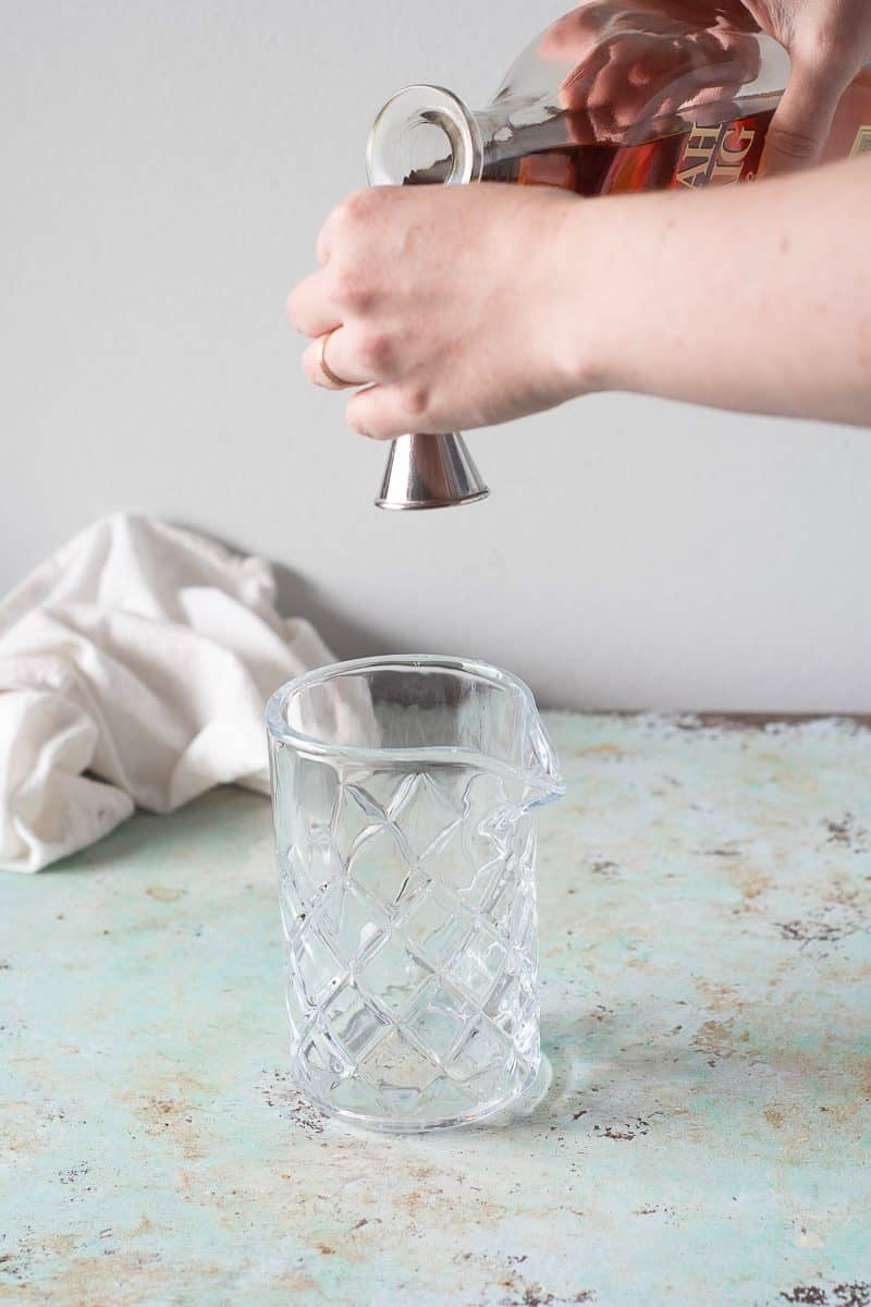 Measuring bourbon into a jigger