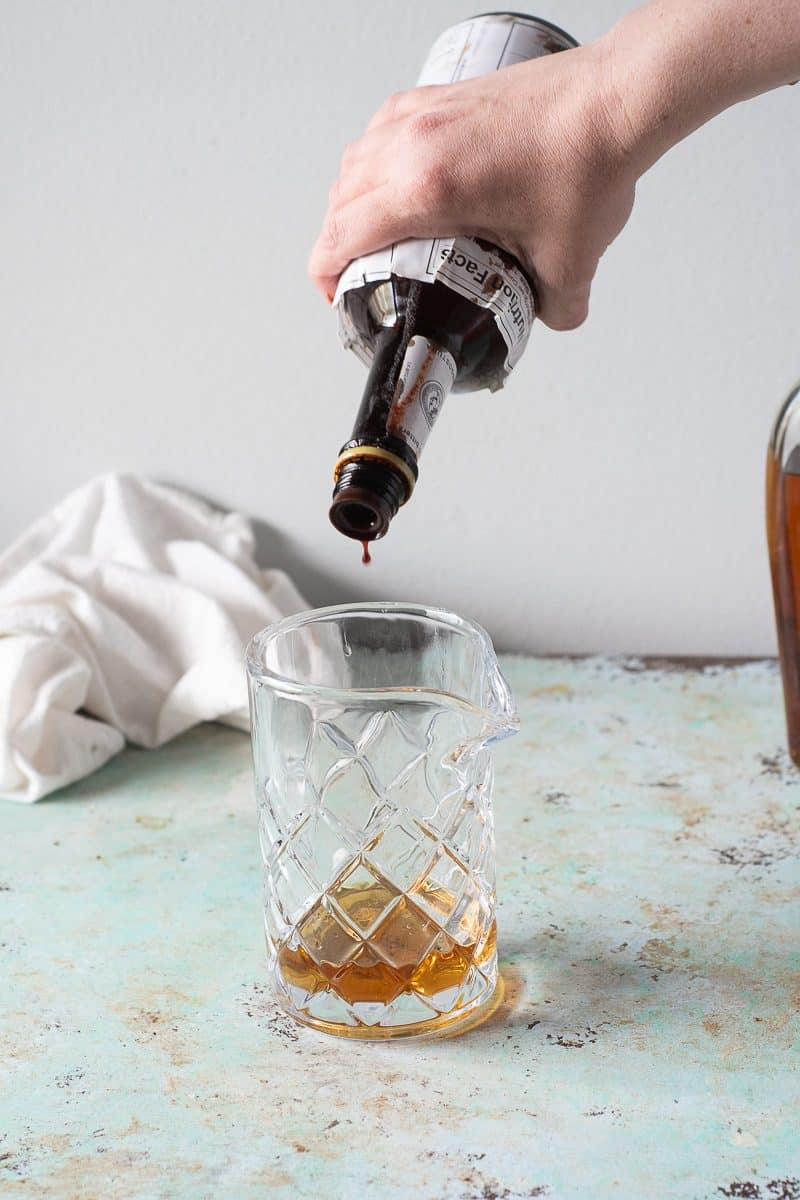 Adding a dash of Angostura bitter to the mixing glass