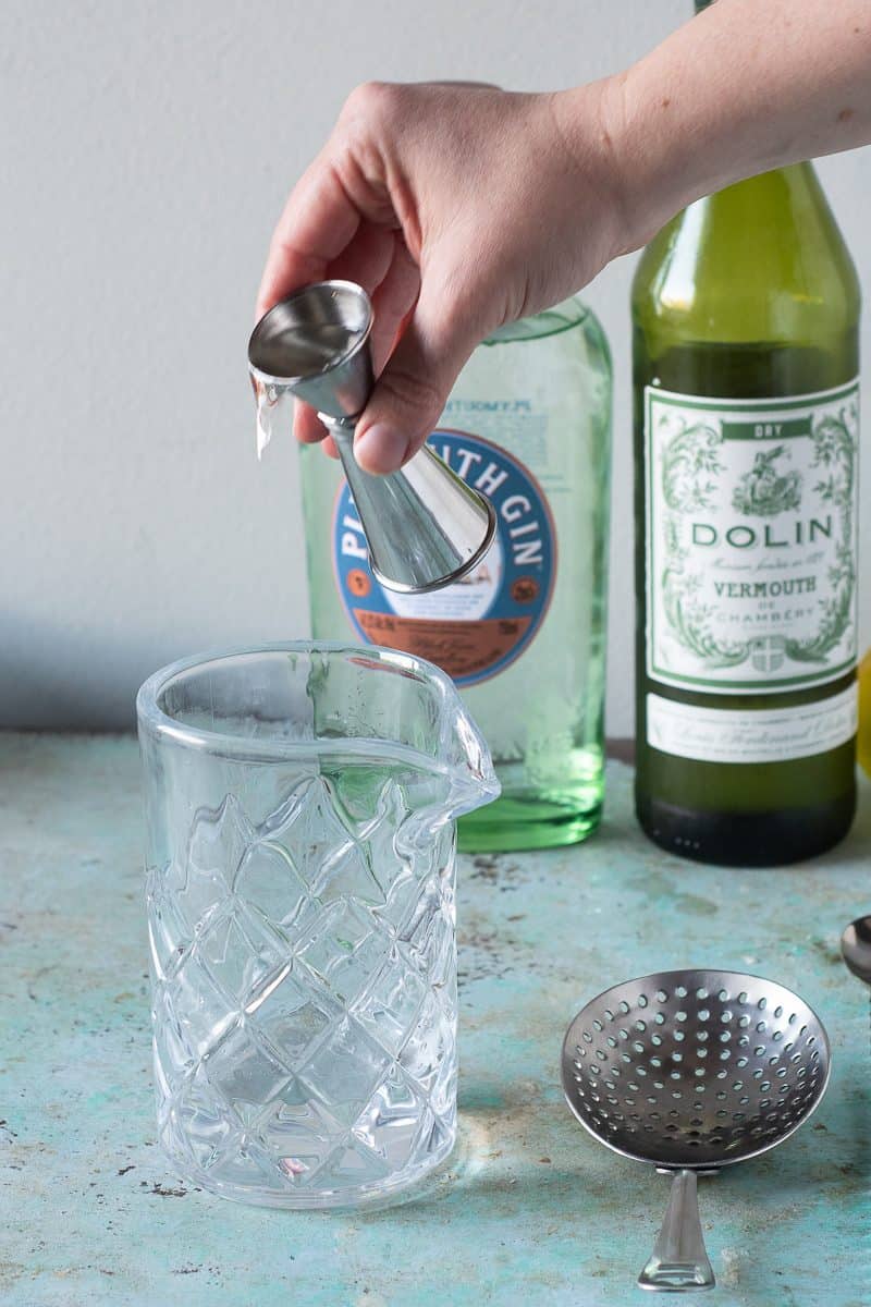 Gin being added to a mixing glass