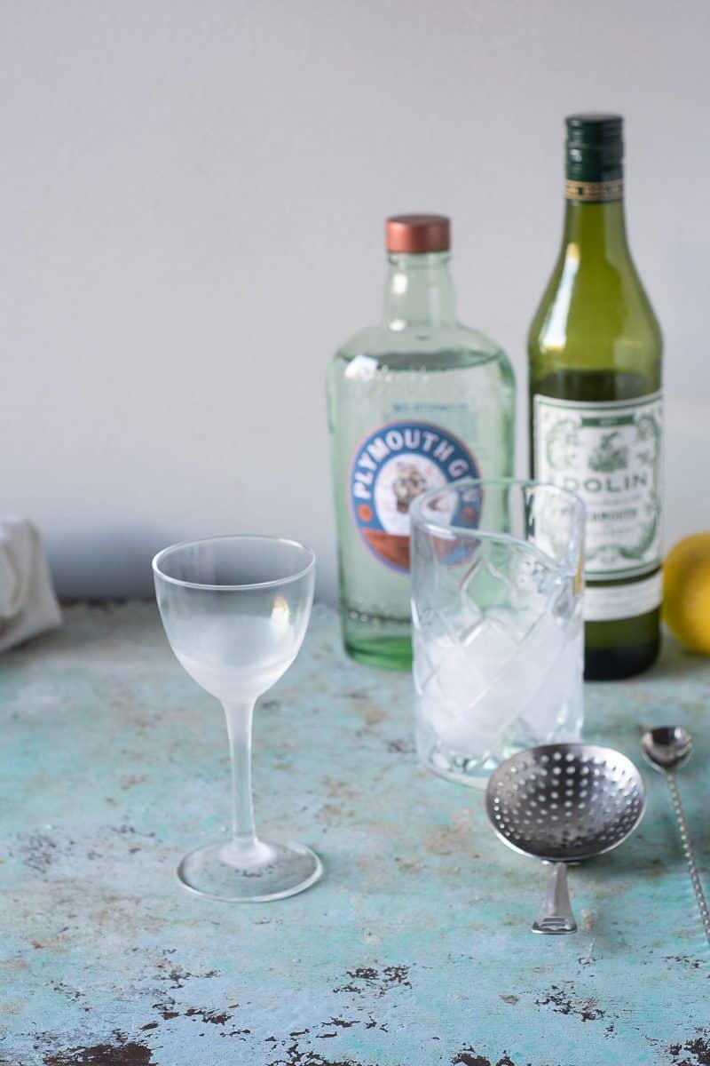 Chilled Nick and Nora glass next to a mixing glass with ice