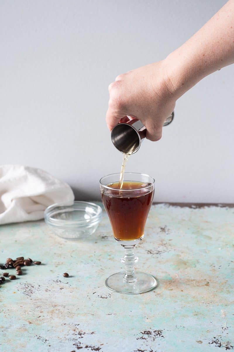 Pouring Irish whiskey into an Irish coffee glass