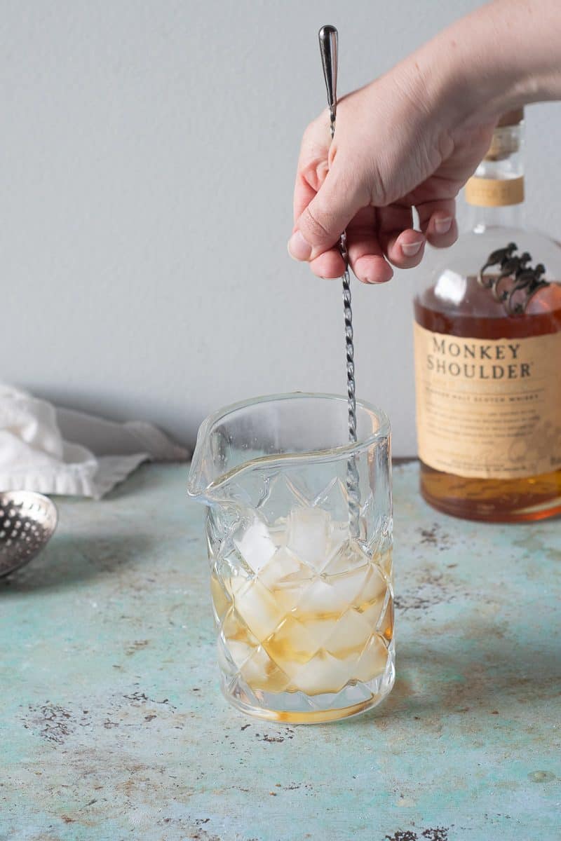 Stirring the Scotch and Drambuie with ice in a mixing glass