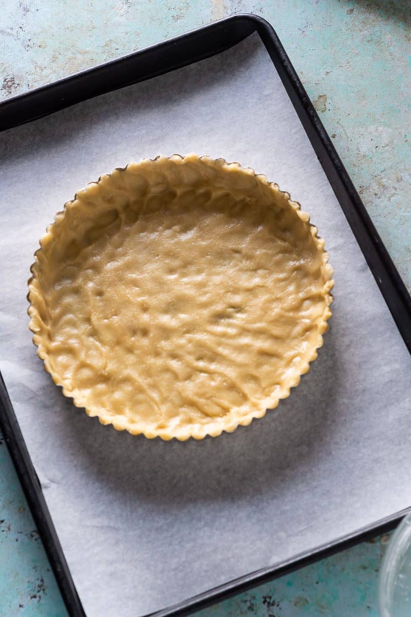 Shortbread tart crust in the pan before baking