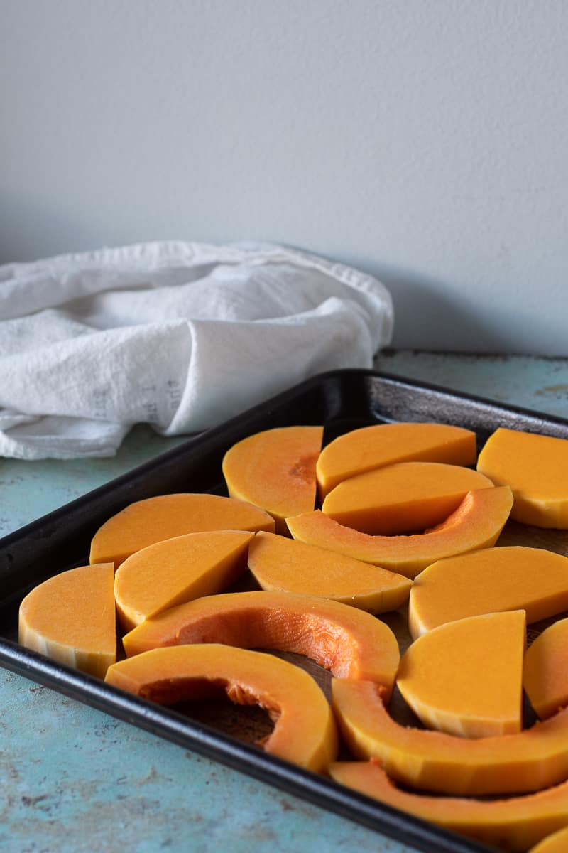 Slices of butternut squash on a baking sheet