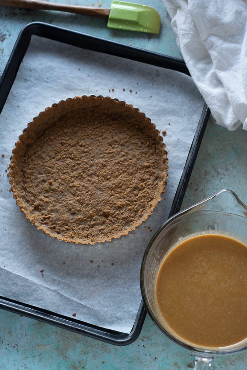 Caramel pumpkin mixture next to a gingersnap tart crust