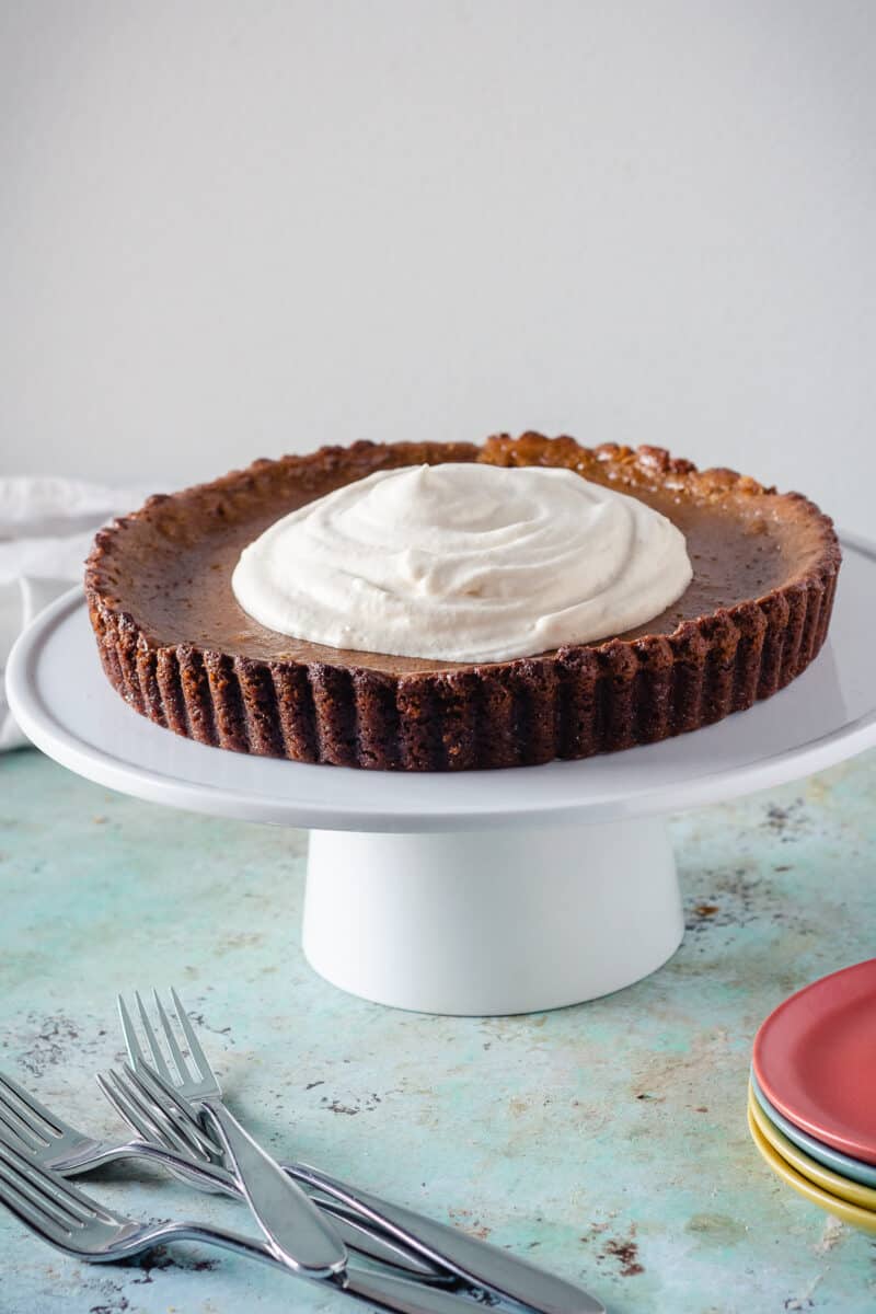 Caramel pumpkin tart on a white cake stand