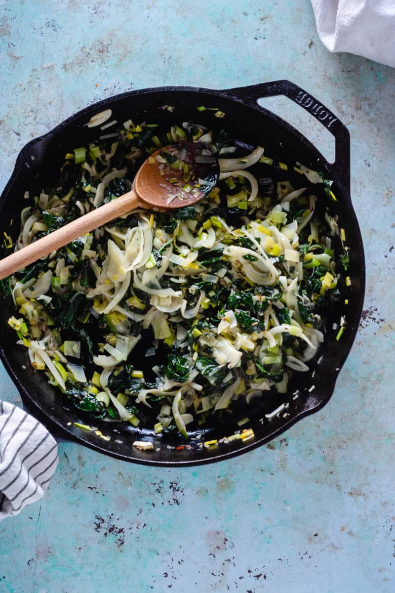 Cast iron skillet with sauteed kale, fennel, leeks, and shallots