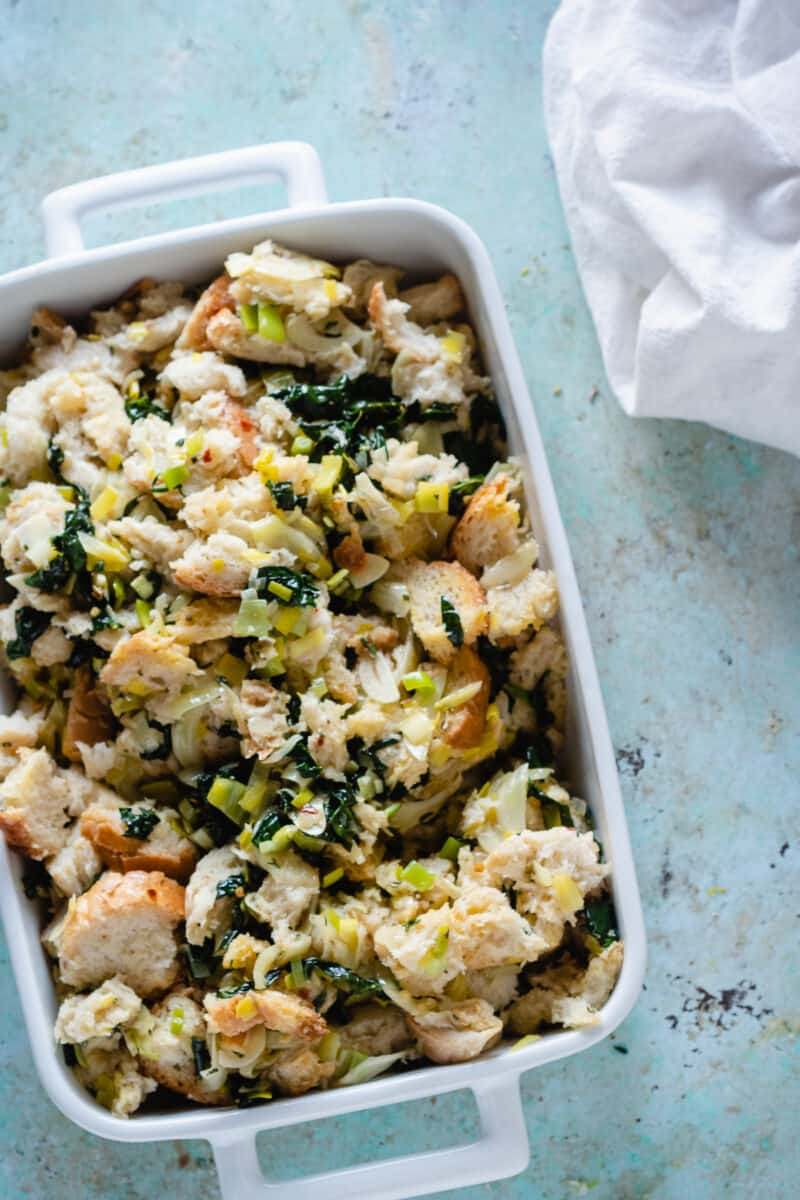 Unbaked fennel and kale stuffing in a baking dish