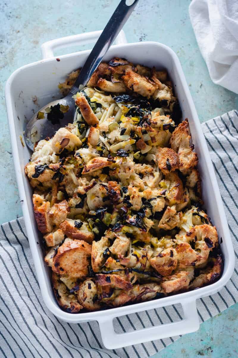 Fennel and Kale Stuffing in a baking dish with a serving spoon