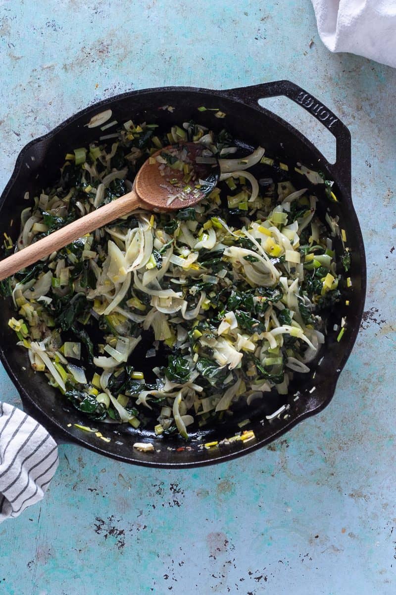 A saute pan with softened leeks, fennel, kale, shallots, garlic, and red pepper flakes