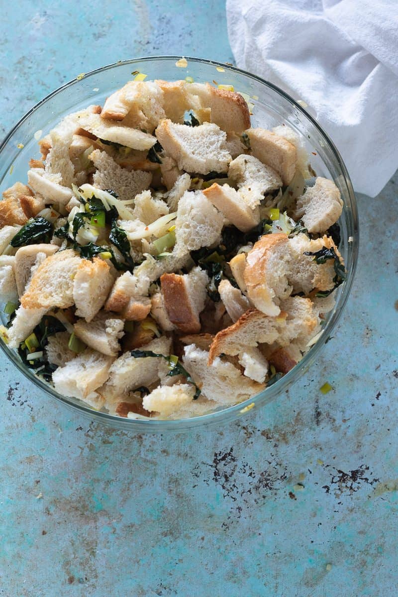 Vegetable mixture and bread mixed together in a bowl, overhead view