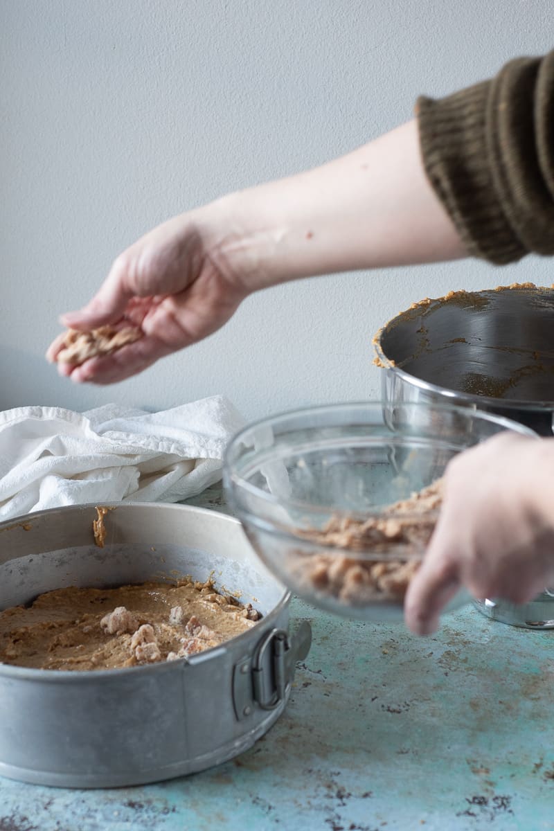 Sprinkling pecan streusel over the pumpkin coffee cake