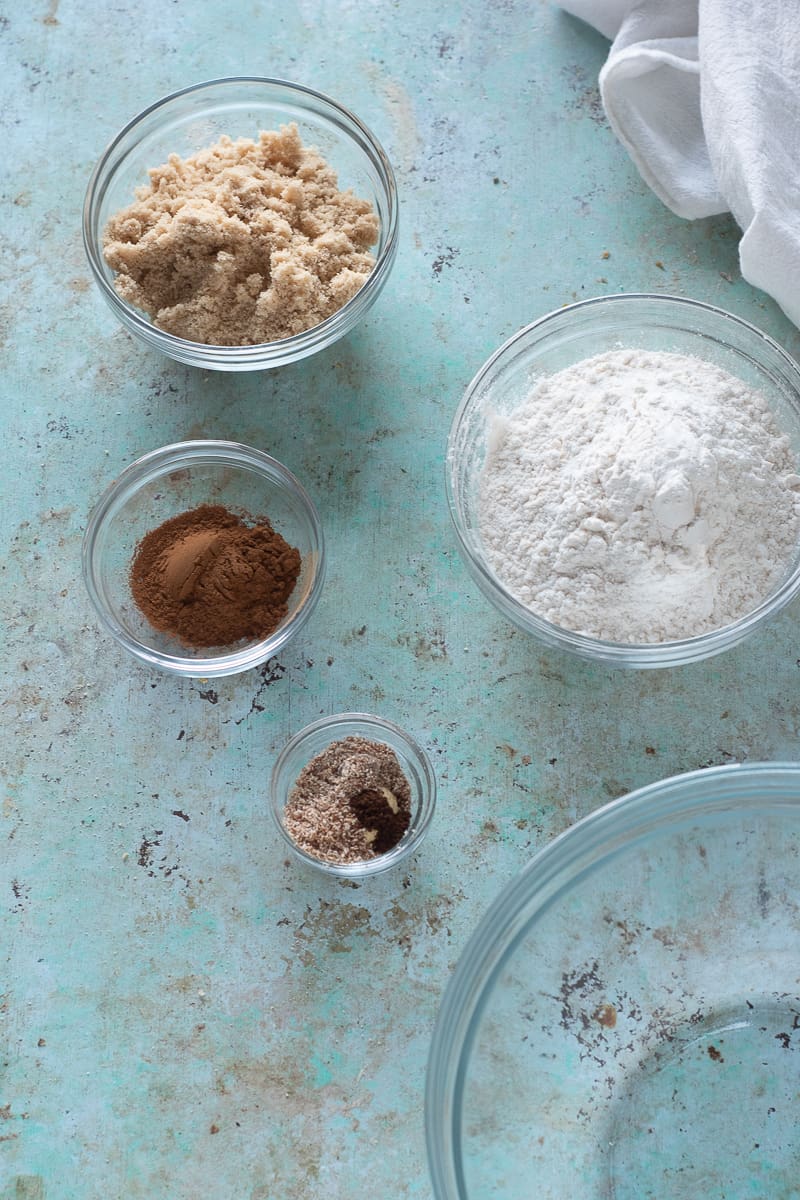 Spices in bowls, brown sugar in a bowl, flour in a bowl