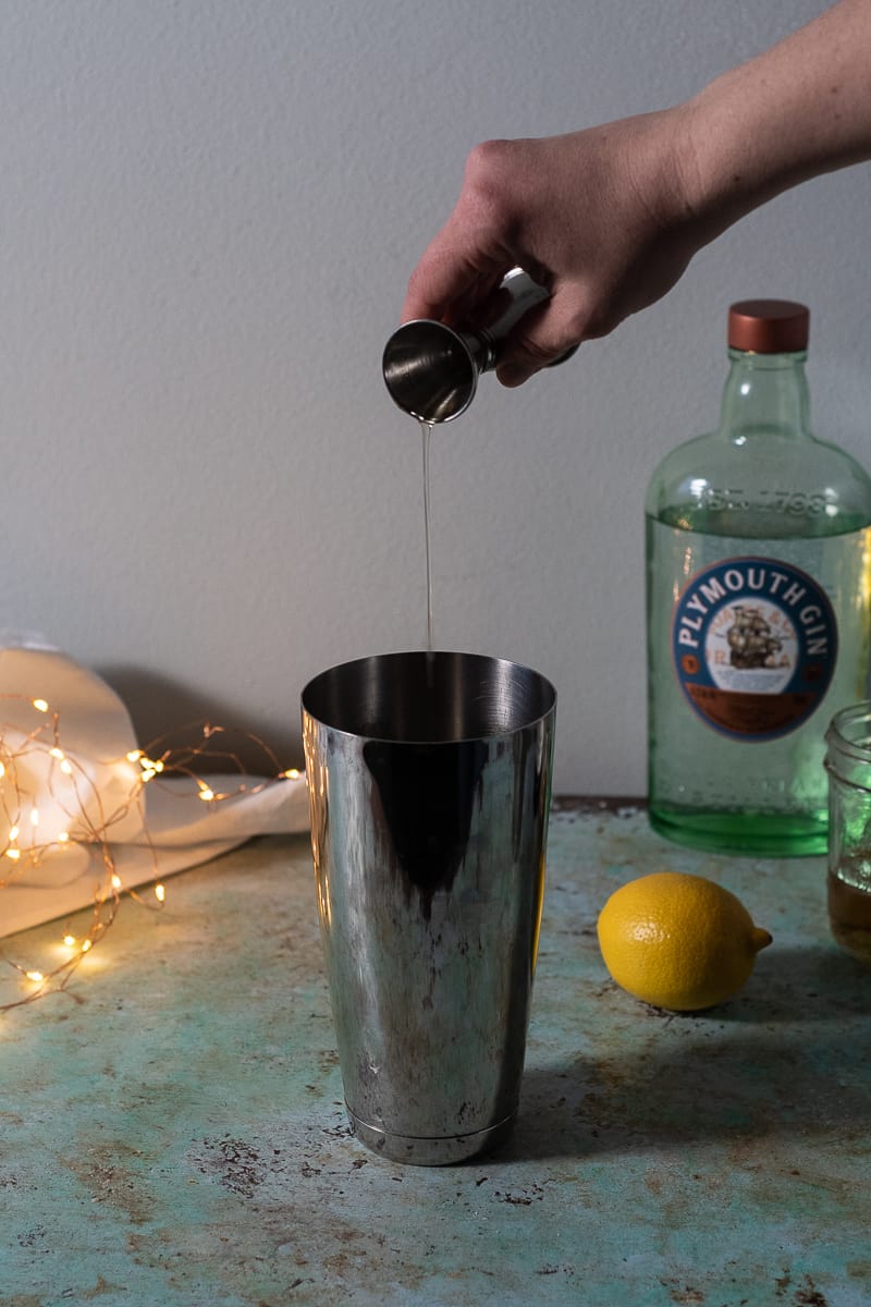 Pouring simple syrup into a cocktail shaker