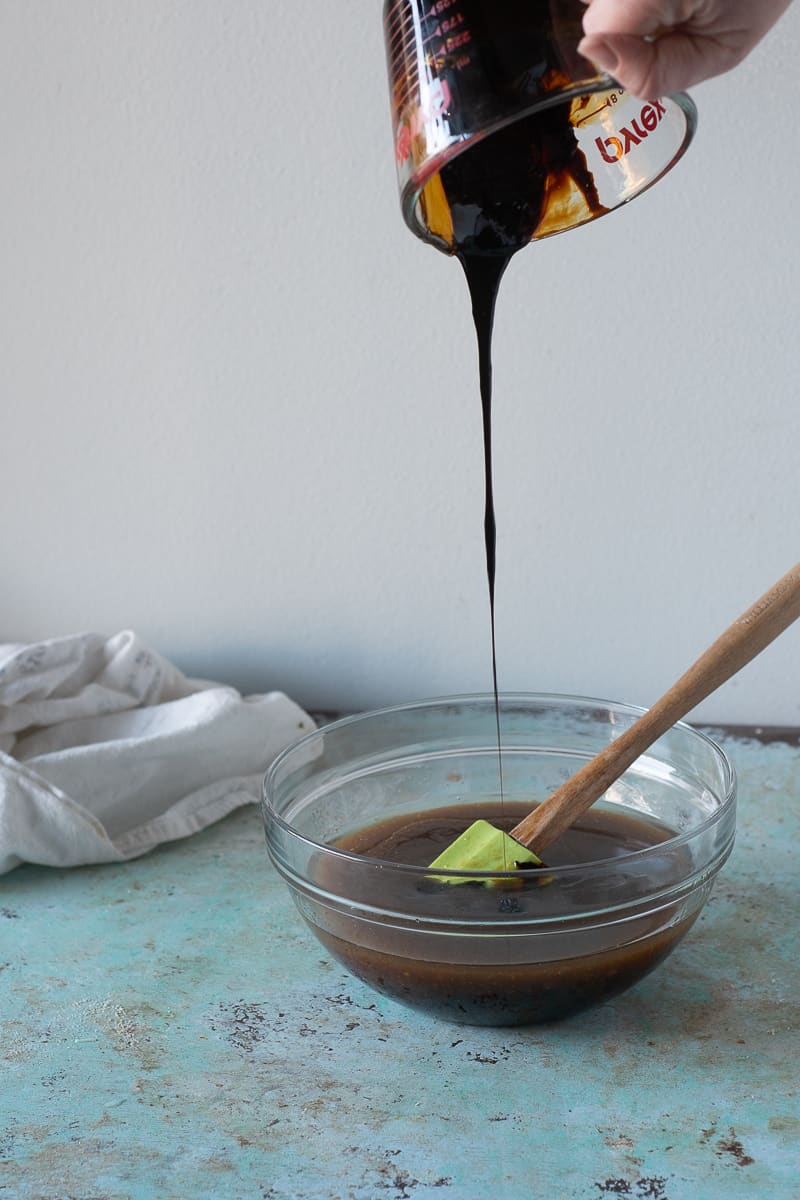 Pouring molasses into the bowl of wet ingredients