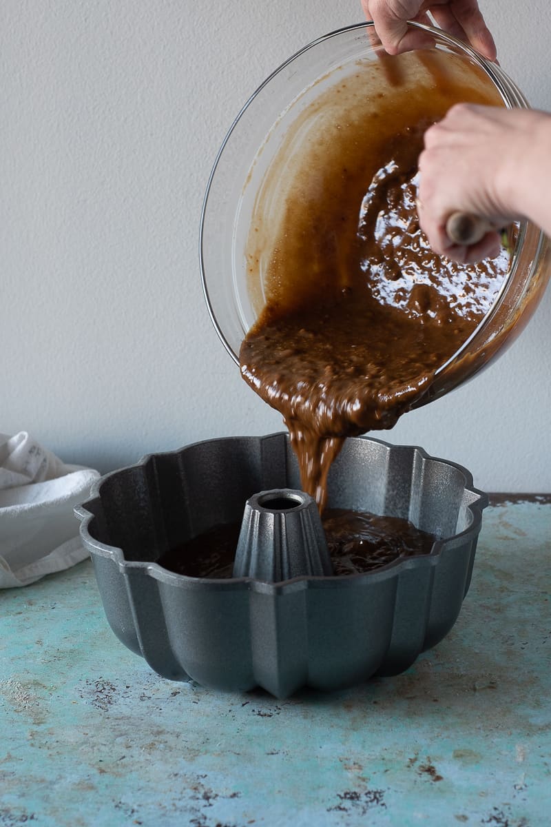 Pouring gingerbread batter into a Bundt cake pan