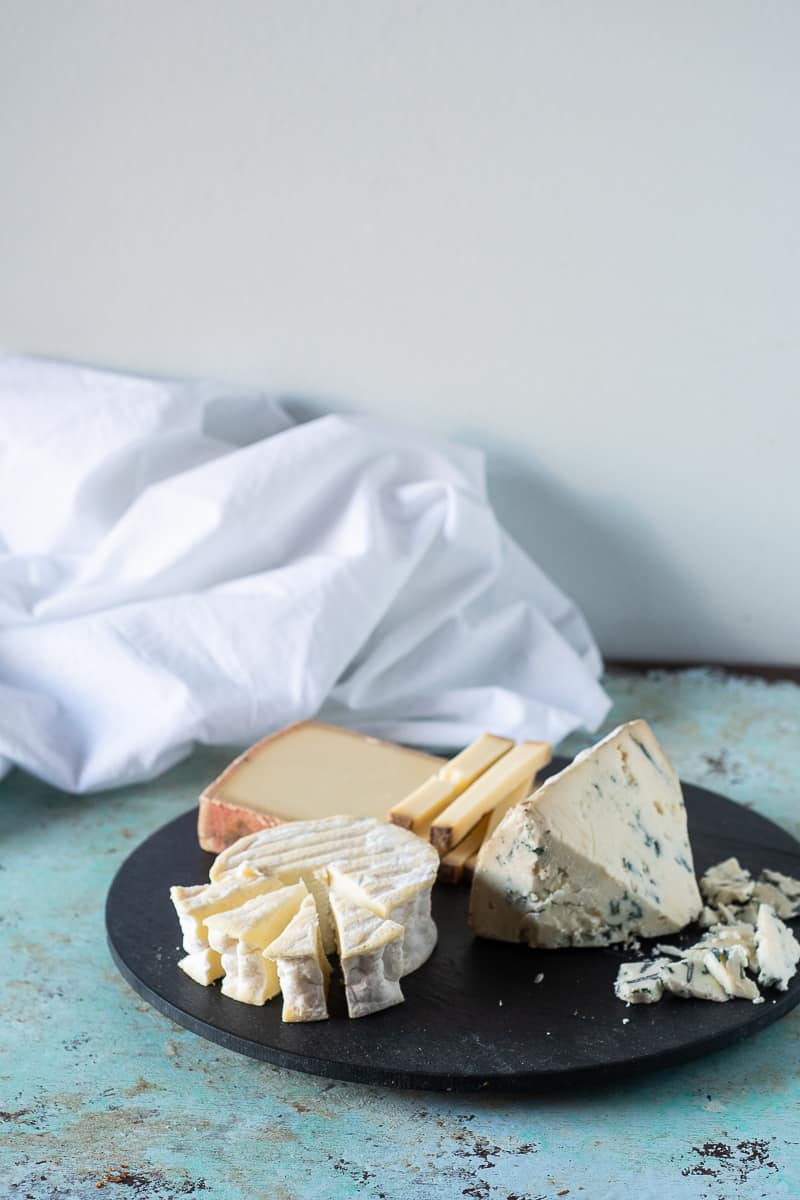 A variety of cheeses on a slate board
