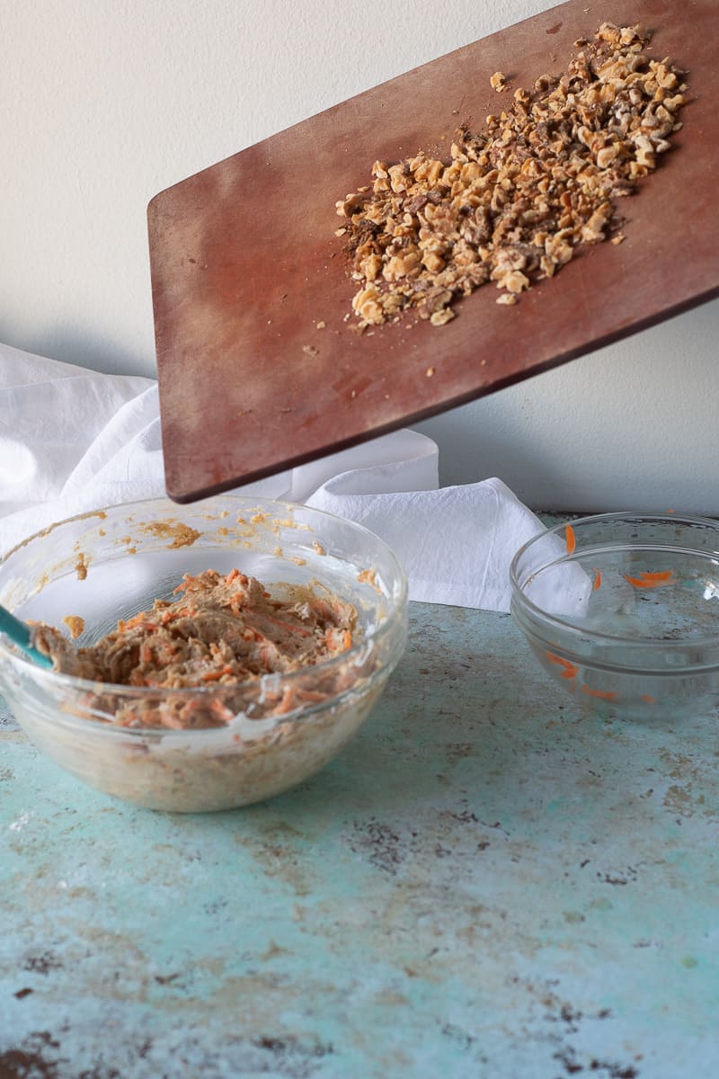 Adding toasted walnuts to the carrot cake batter