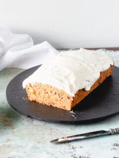 Carrot Loaf Cake with Cream Cheese Frosting, with slice removed to expose crumb
