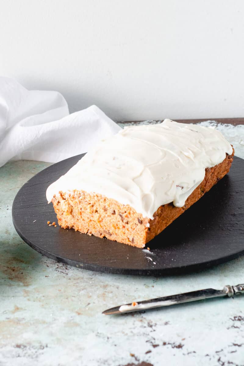 Carrot Loaf Cake with Cream Cheese Frosting, with slice removed to expose crumb