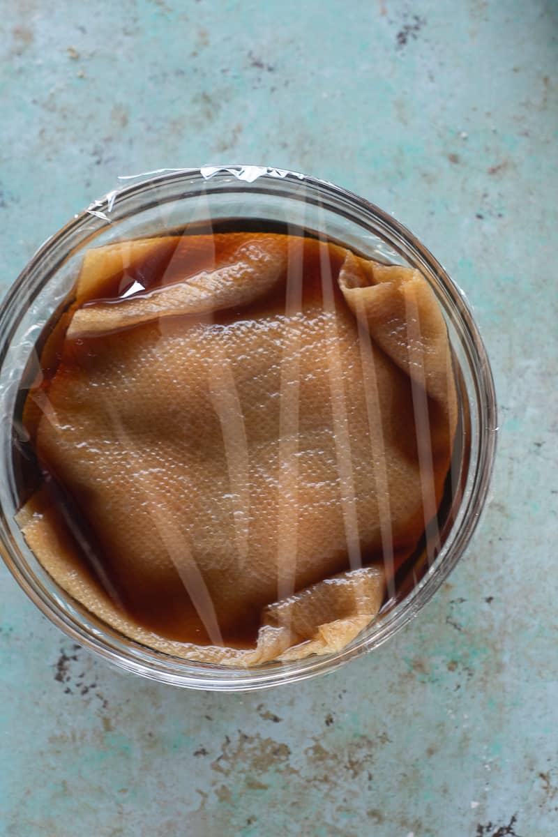 Paper Towel soaked in soy sauce marinade over ramen eggs