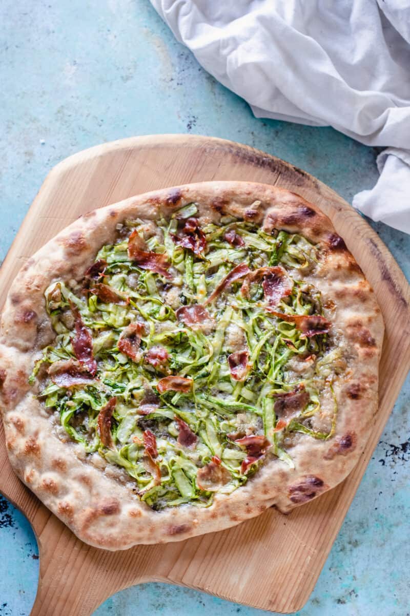 Asparagus Pizza on a wooden peel