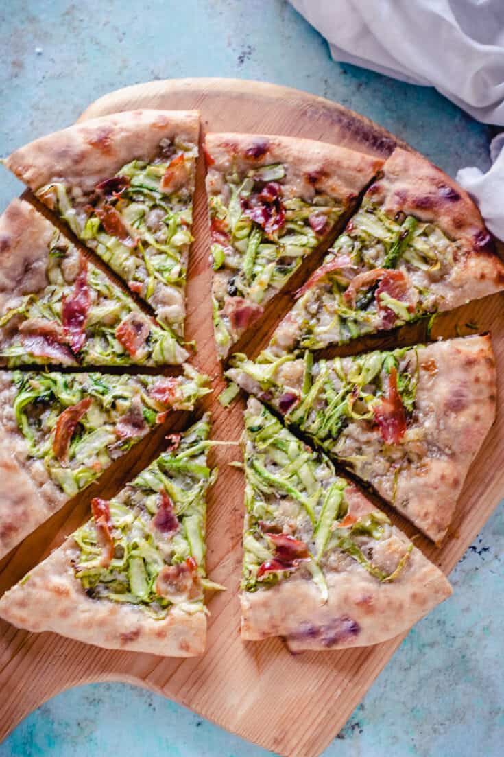Asparagus Pizza, sliced, on a wooden peel