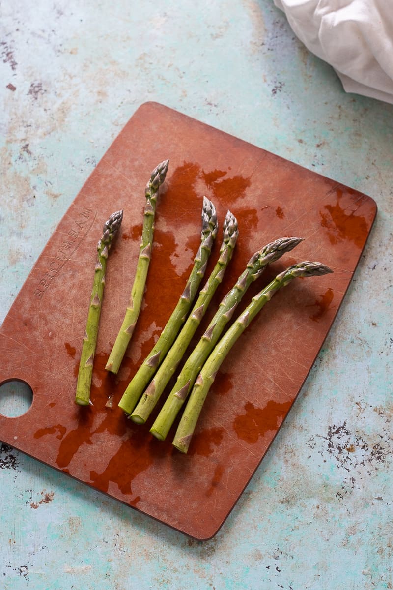 Asparagus spears, trimmed, on a cutting board