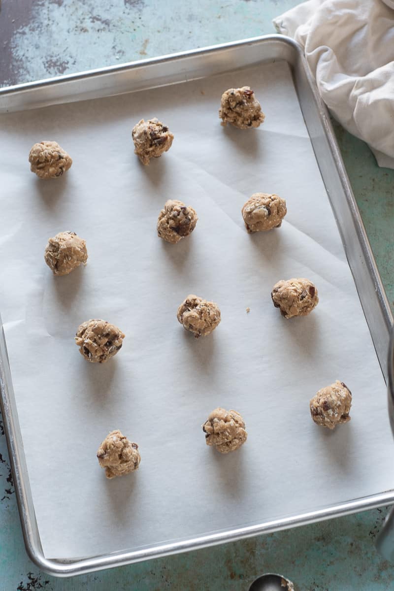 Balls of oatmeal raisin cookie dough on a sheet pan