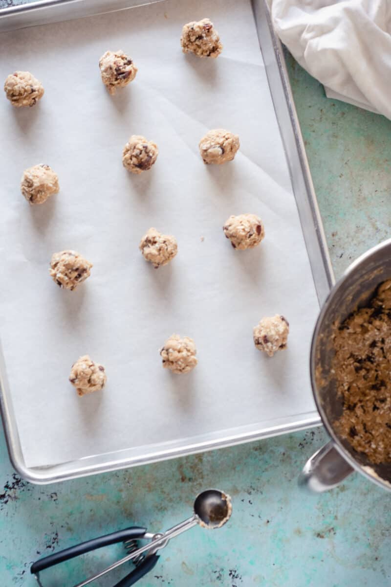 Balls of oatmeal raisin cookie dough on a sheet pan