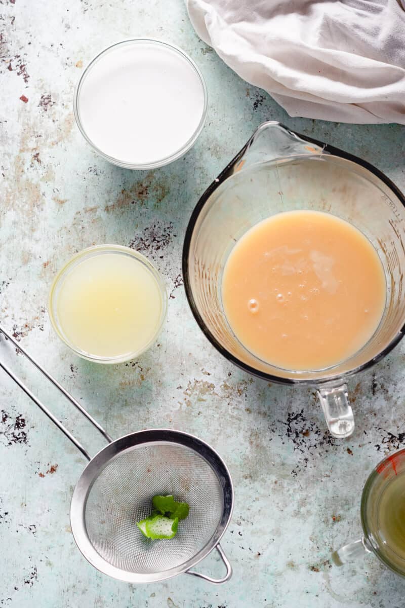 Coconut milk in a bowl, sweetened condensed coconut milk in a bowl, lime juice in a bowl with lime zest in a strainer