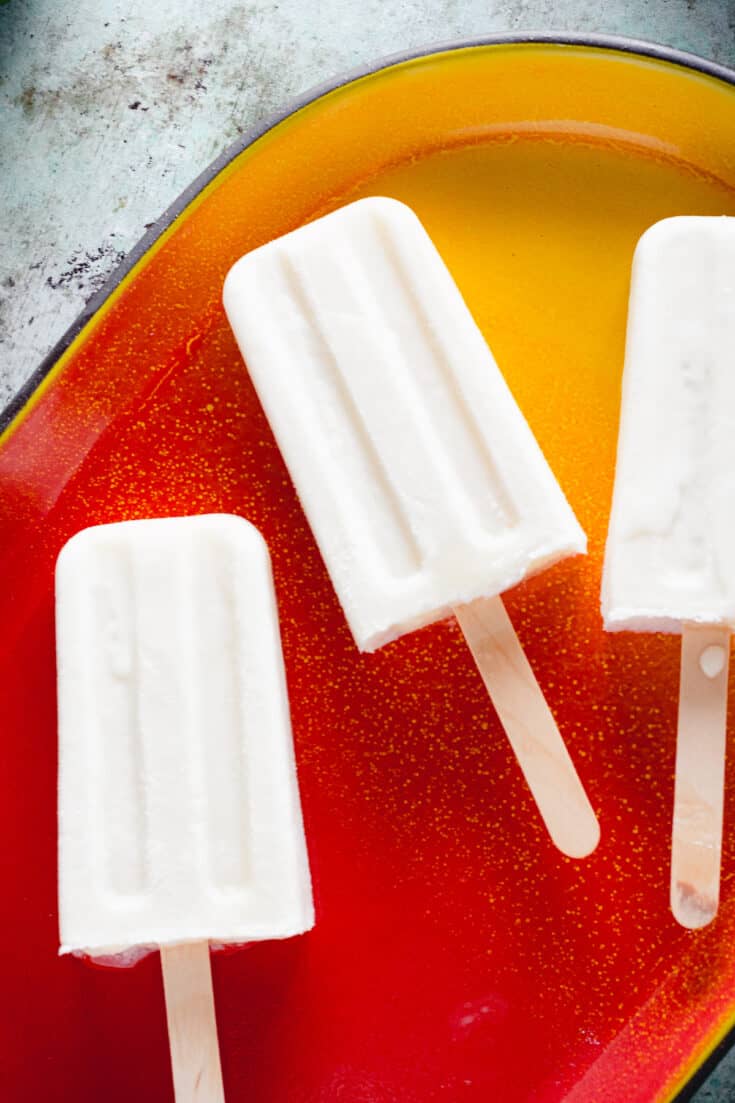 Coconut Lime Popsicles on red and yellow tray