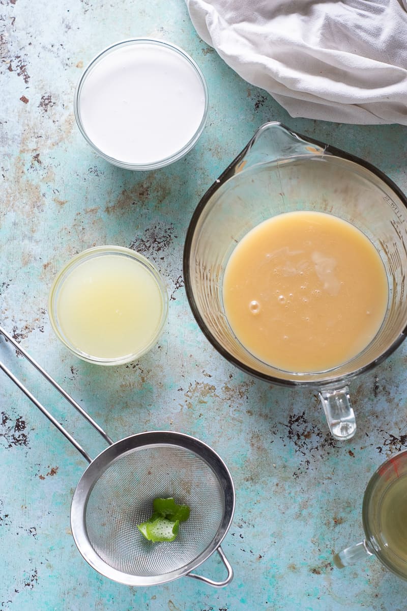 Coconut milk in a bowl, sweetened condensed coconut milk in a bowl, lime juice in a bowl with lime zest in a strainer