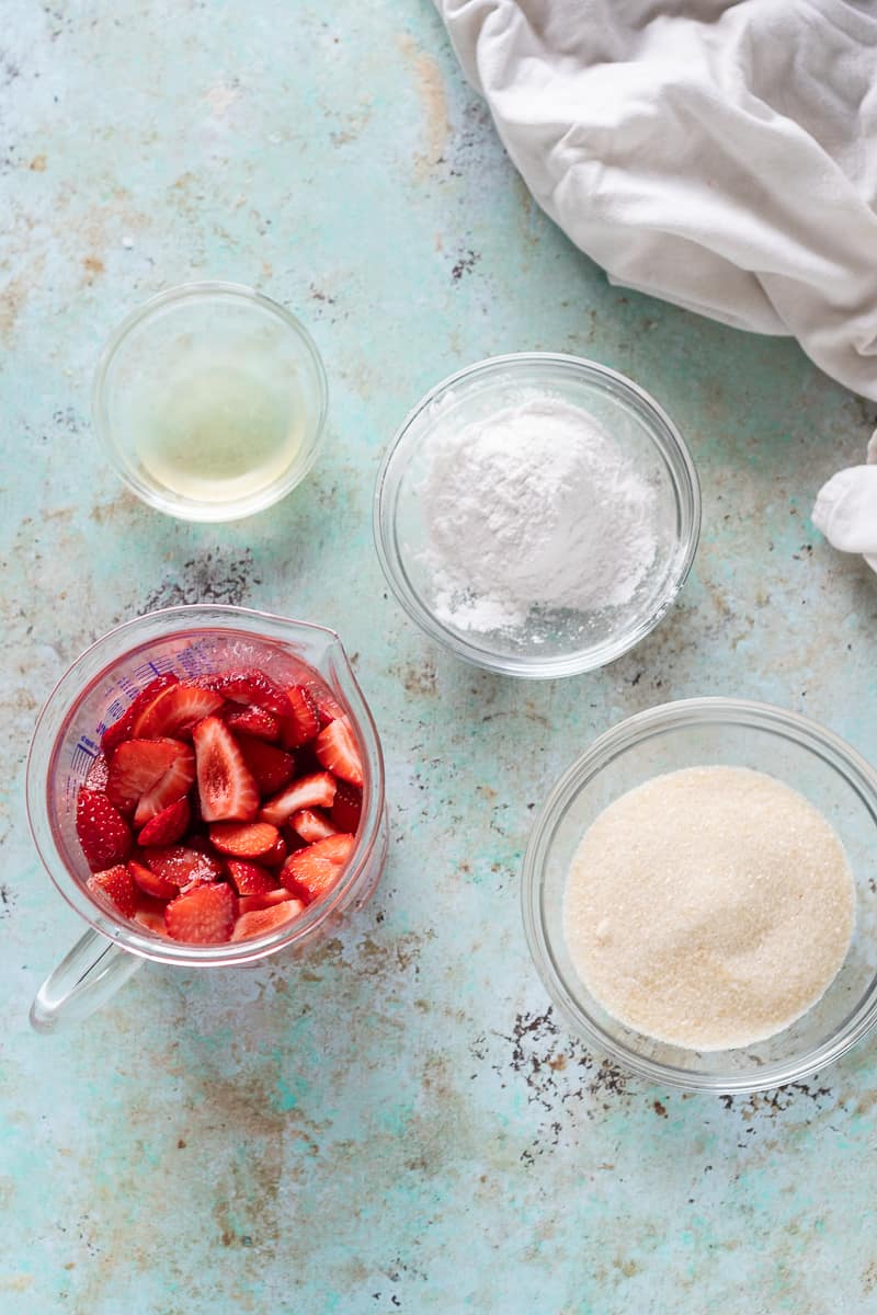 Slice strawberries, lemon juice, tapioca starch, and sugar in bowls