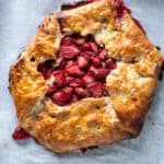 Strawberry galette on parchment paper on a sheet pan, overhead shot