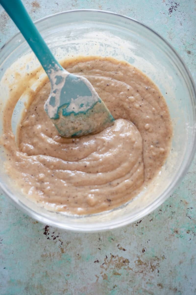 Spoon cake batter in a bowl with a spatula