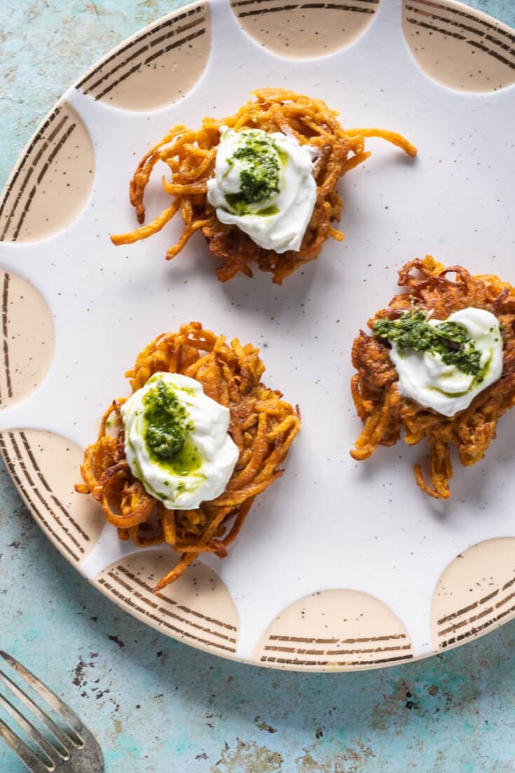 Curried Sweet Potato Latkes with Yogurt and Cilantro Mint Chutney on a plate