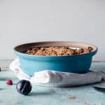 Raspberry plum crisp in a blue baking dish