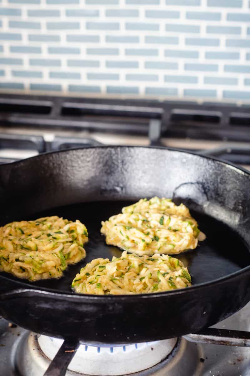 Zucchini fritters in a cast iron pan, raw side up