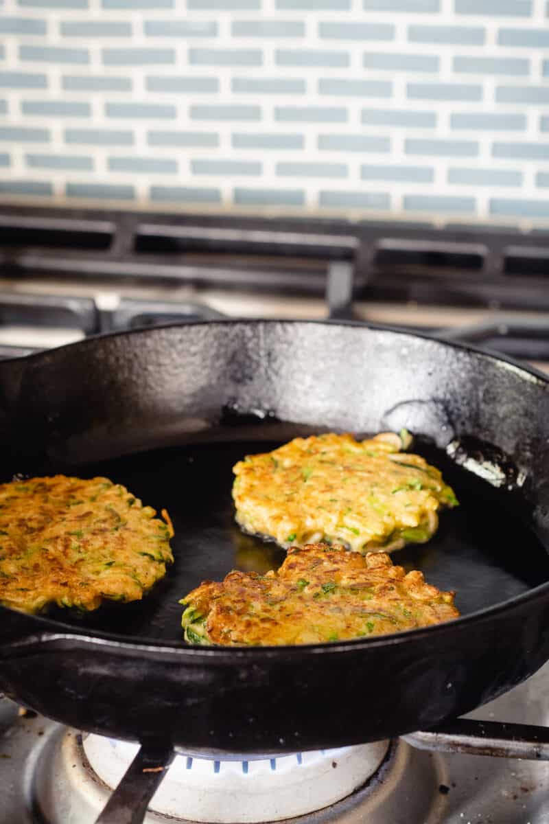 Zucchini fritters in a cast iron pan, cooked side up