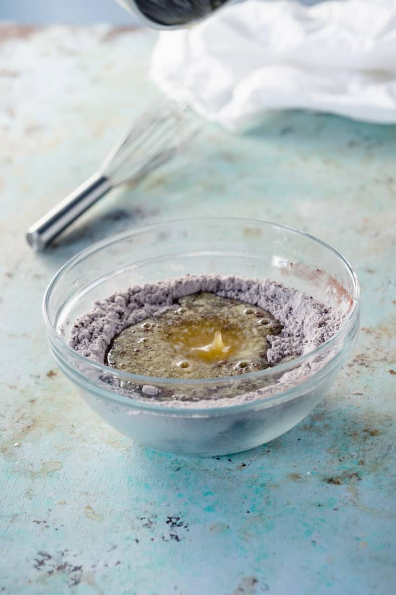 Butter poured into a bowl with flour and cocoa powder