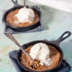 Two mini chocolate chip skillet cookies topped with vanilla ice cream