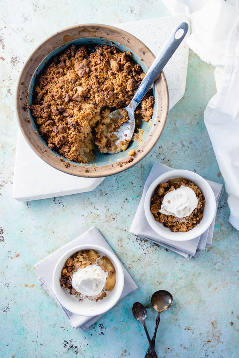 Apple crisp with two bowls with ice cream